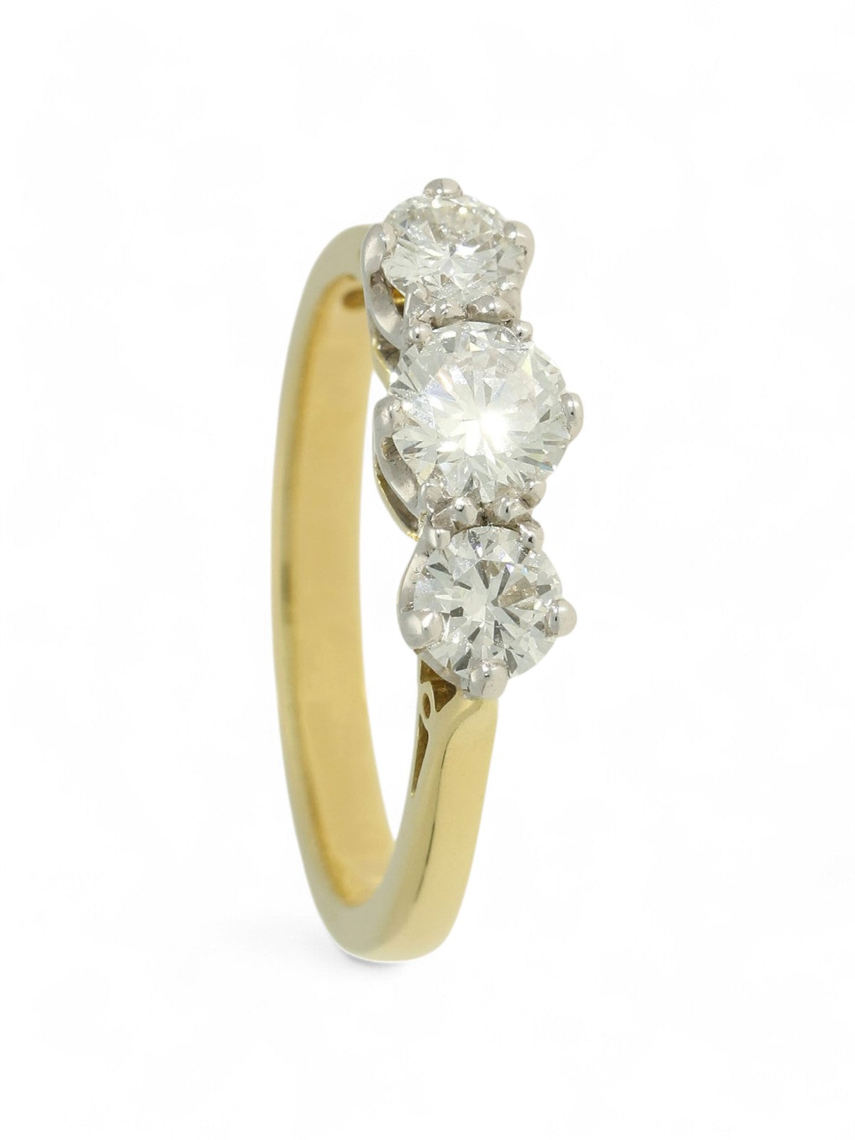Three stone diamond ring with a yellow gold shank on a white background.