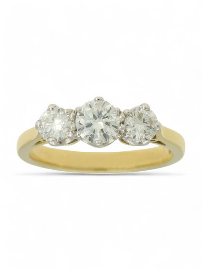 Three stone diamond ring with a yellow gold shank on a white background.