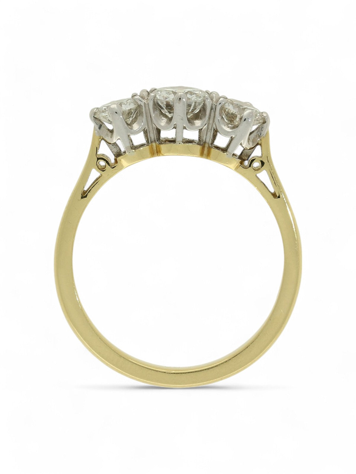 Three stone diamond ring with a yellow gold shank on a white background.