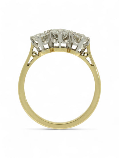Three stone diamond ring with a yellow gold shank on a white background.