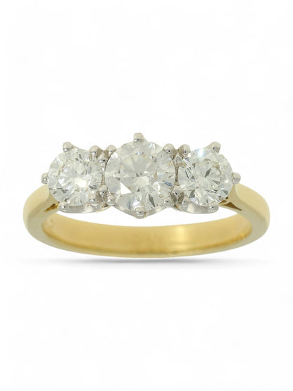 Three stone diamond ring with a yellow gold shank on a white background.
