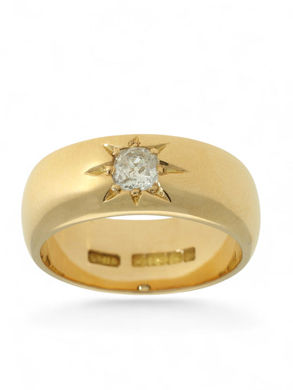 18ct yellow gold wide band ring with a single diamond in a star setting on a white background.