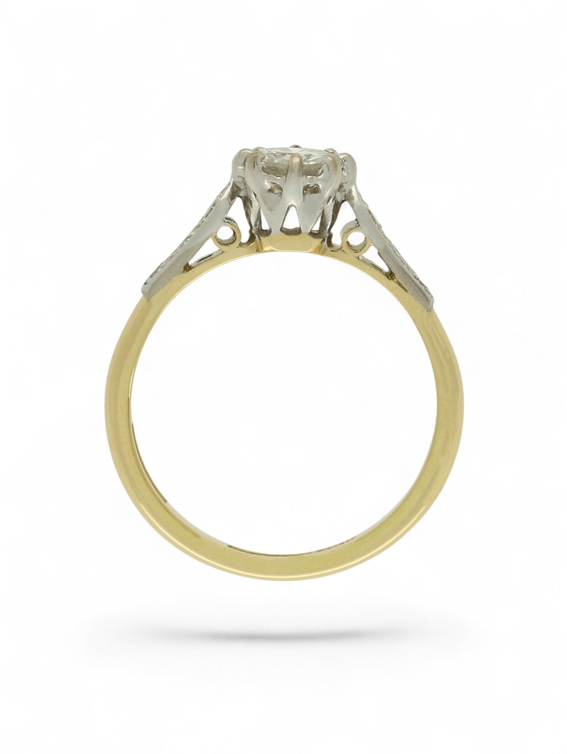 Diamond single stone ring with an eight-claw platinum setting, yellow gold band, and diamond-set shoulders.