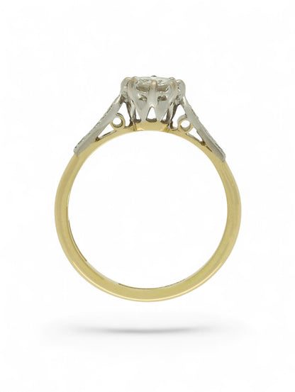 Diamond single stone ring with an eight-claw platinum setting, yellow gold band, and diamond-set shoulders.