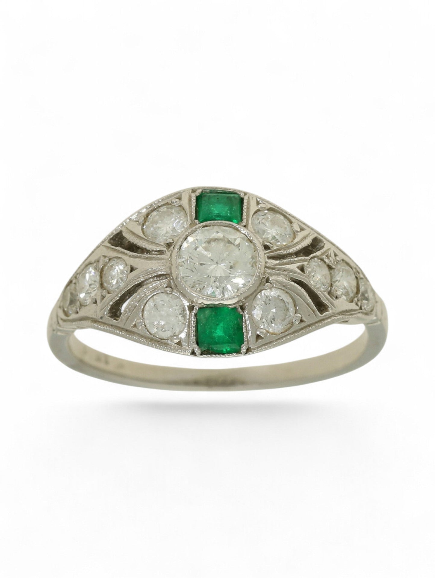 Platinum art deco-style ring with round-cut diamonds and square-cut emeralds on a white background.