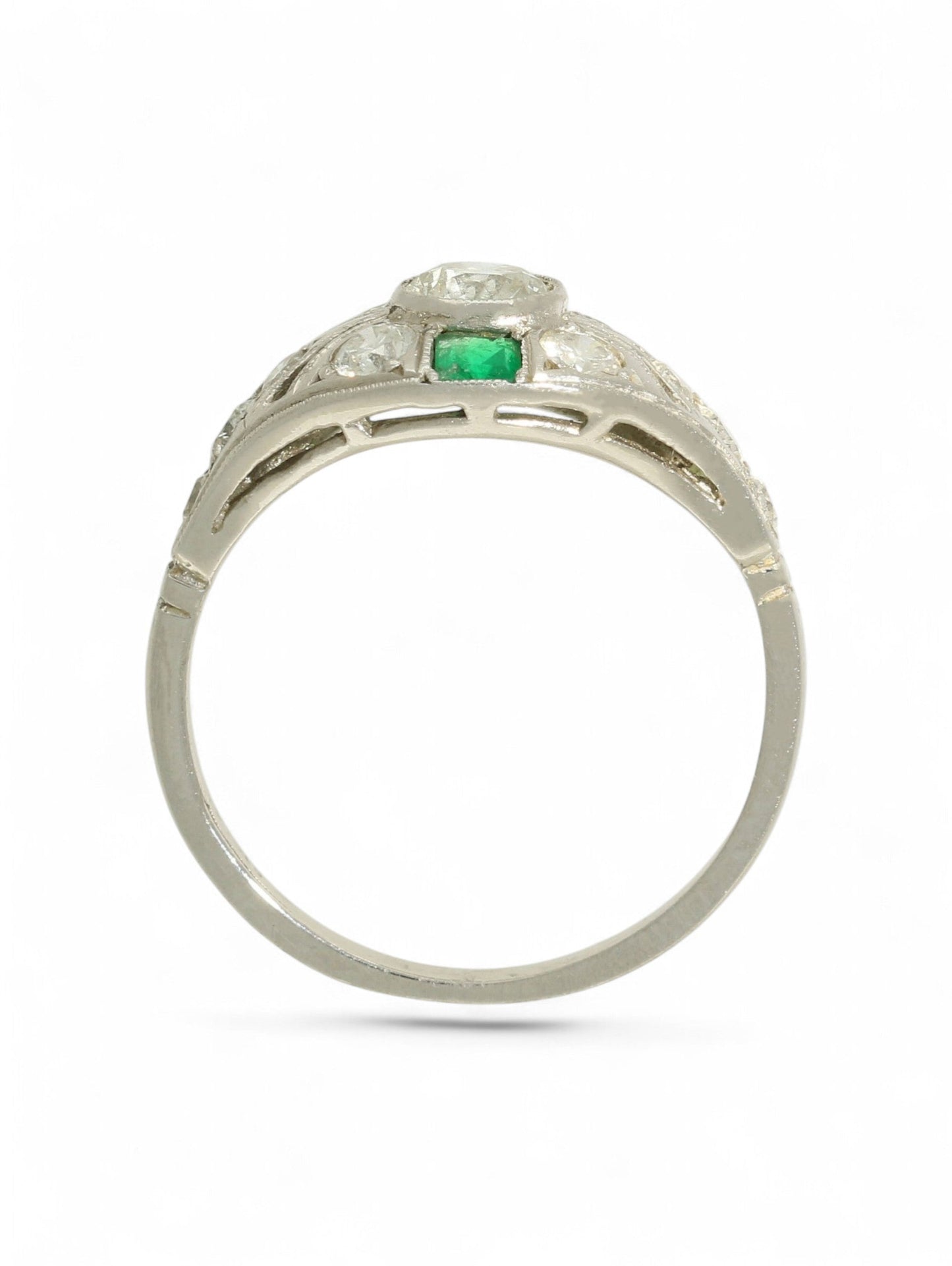 Platinum art deco-style ring with round-cut diamonds and square-cut emeralds on a white background.