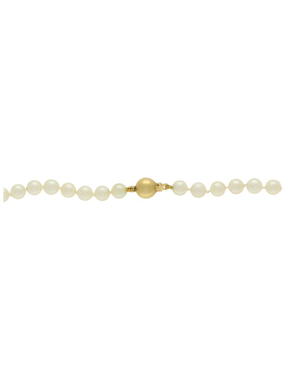 Single-row of white pearls with yellow-gold ball clasp on a white background.
