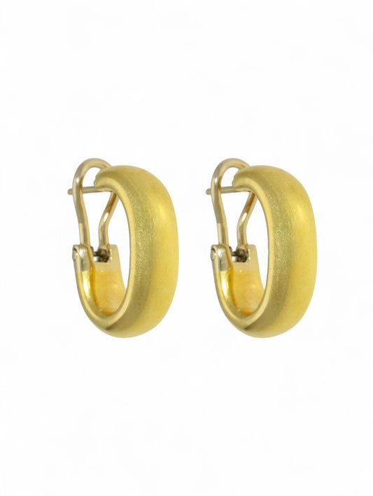 Yellow-gold oval hoop earrings with hinged fitting on a white background.