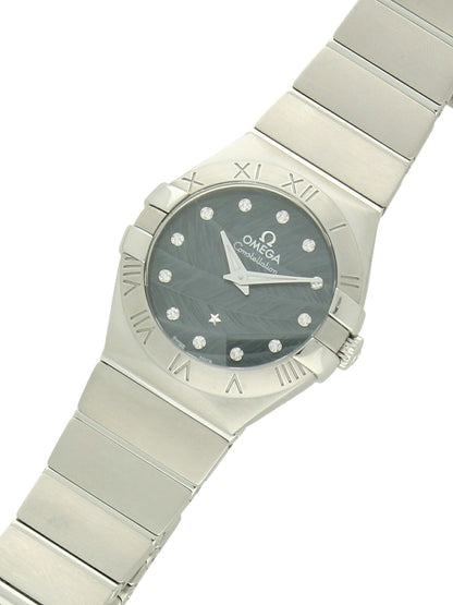 Omega Constellation with steel bracelet and blue  feather, diamond-set dial on a white background.