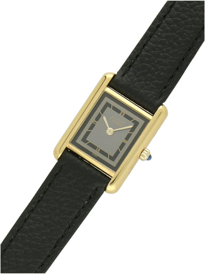 Yellow gold Cartier watch with a black leather strap and grey dial on a white background.