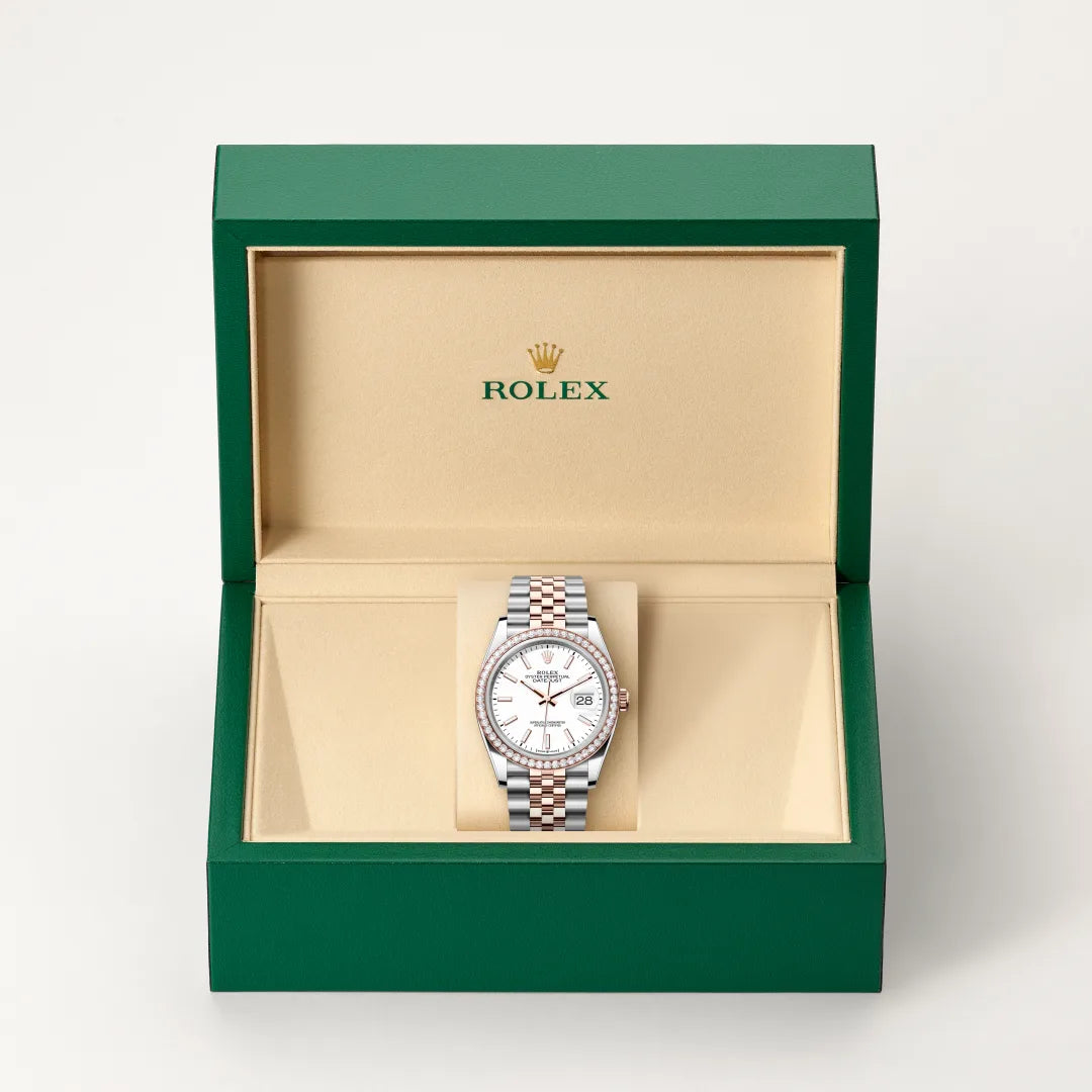Rolex Datejust watch in a green and beige presentation box on a light background.