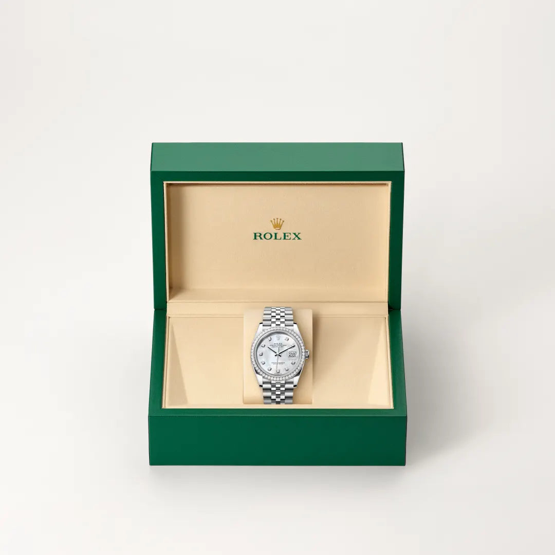 Rolex Datejust watch in a green and beige presentation box on a light background.