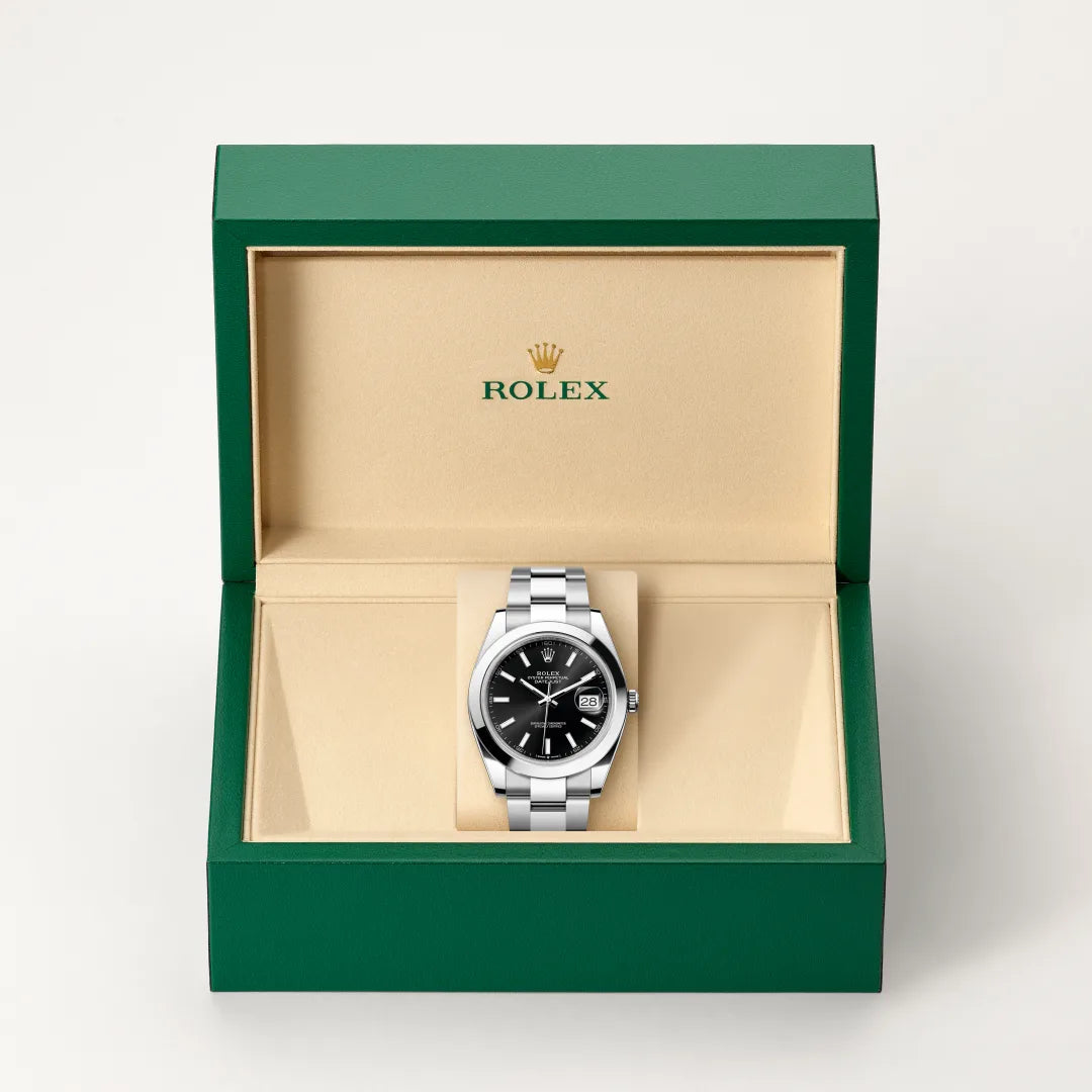 Rolex Datejust watch in a green and beige presentation box on a light background.