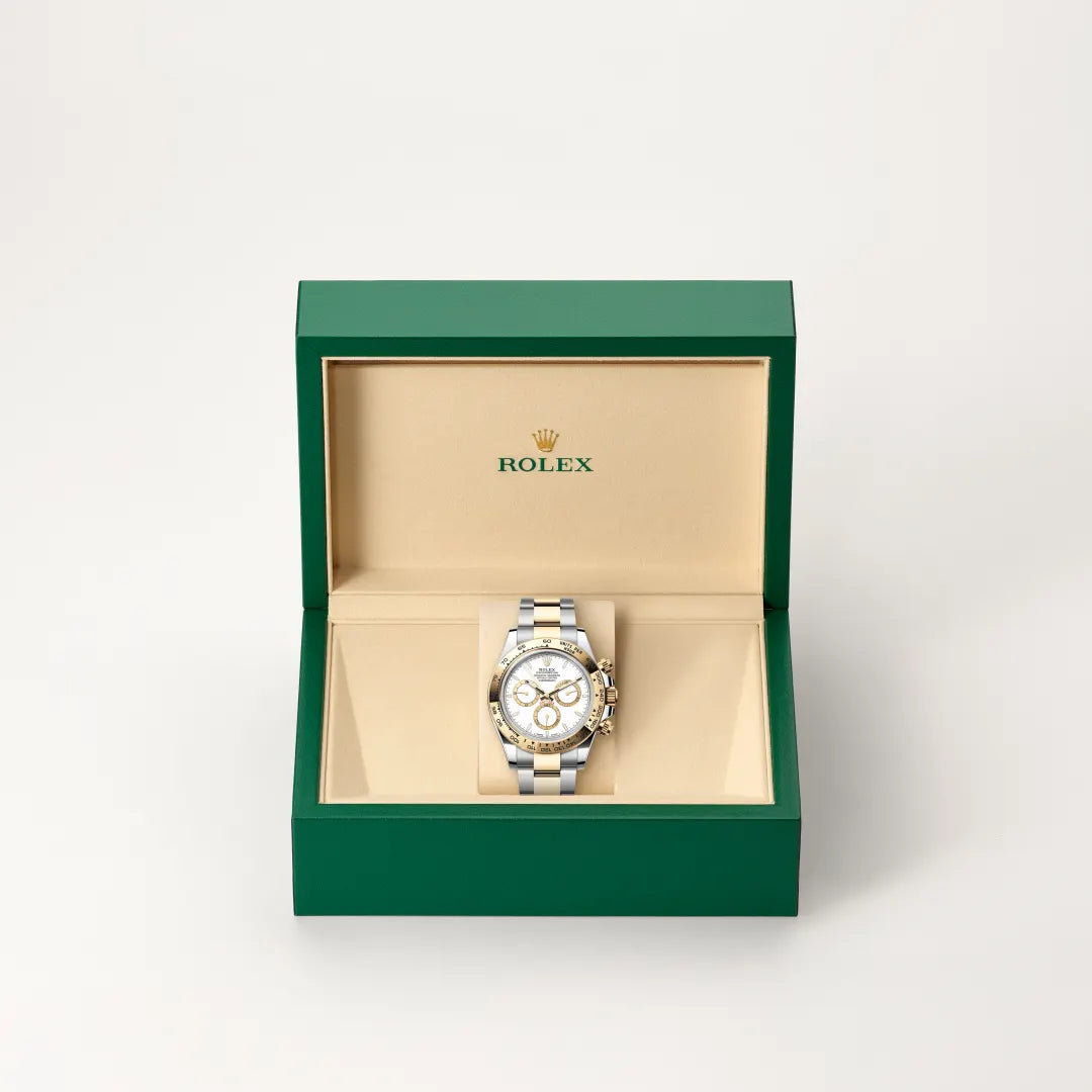 Rolex Cosmograph Daytona watch in a green and beige presentation box on a light background.