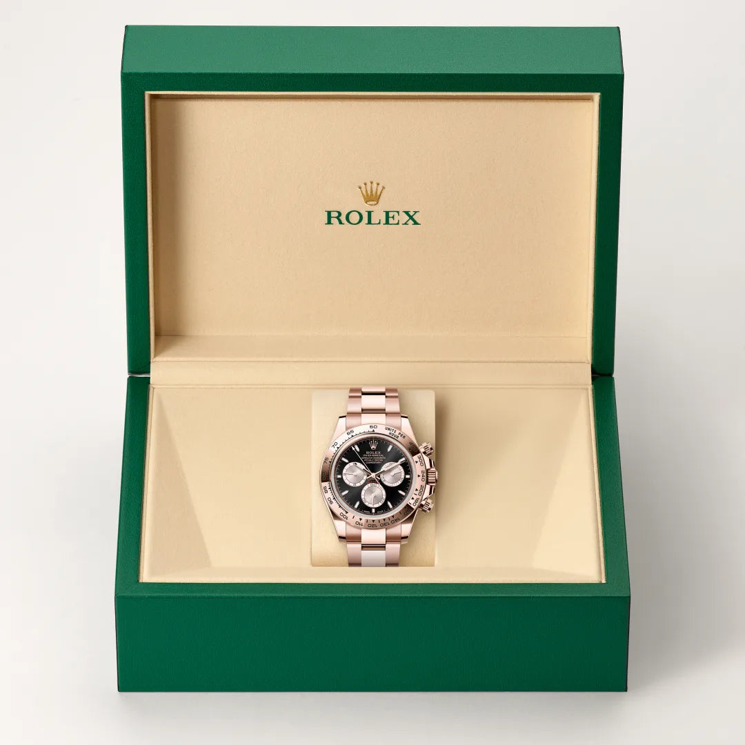 Rolex Cosmograph Daytona watch in a green and beige presentation box on a light background.