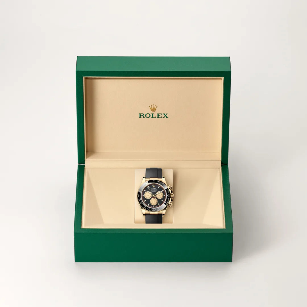 Rolex Cosmograph Daytona watch in a green and beige presentation box on a light background.