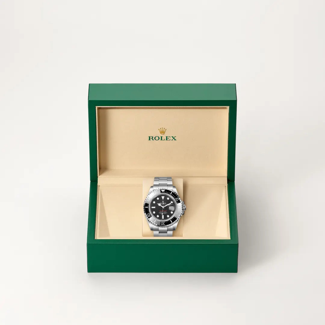 Rolex Sea-Dweller watch in a green and beige presentation box on a light background.