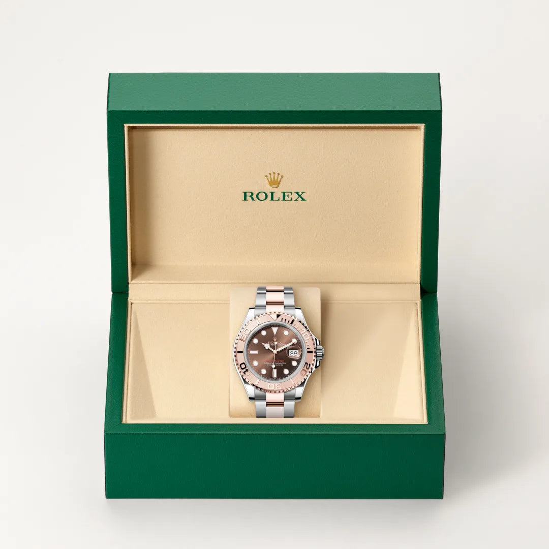 Rolex Yacht-Master watch in a green and beige presentation box on a light background.