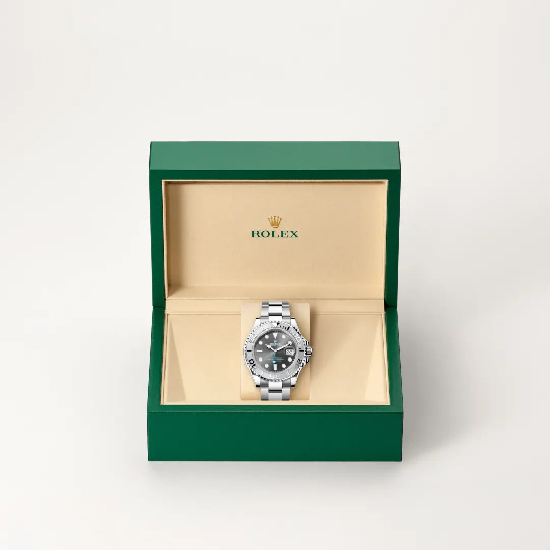 Rolex Yacht-Master watch in a green and beige presentation box on a light background.