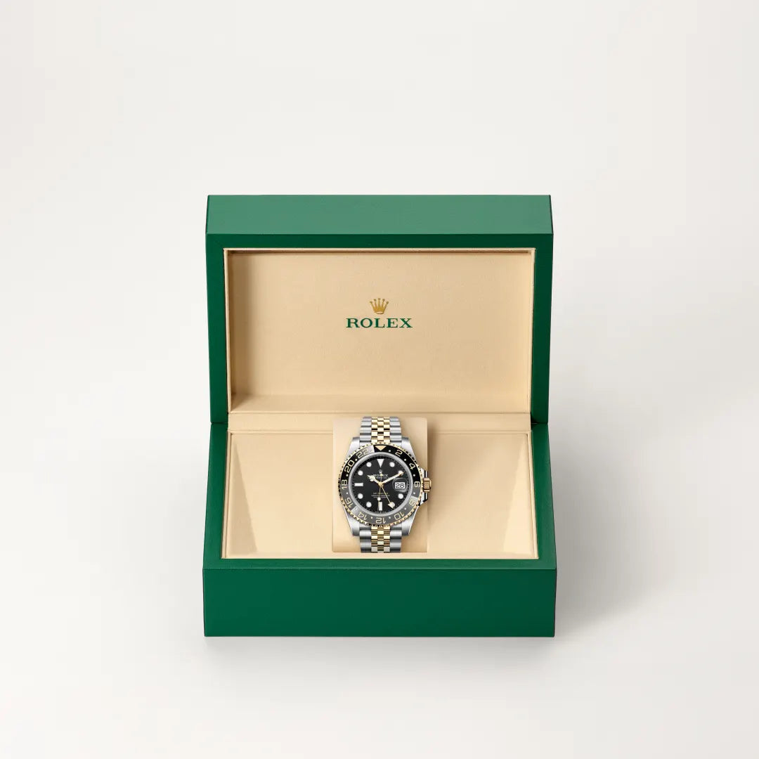 Rolex GMT-Master II watch in a green and beige presentation box on a light background.