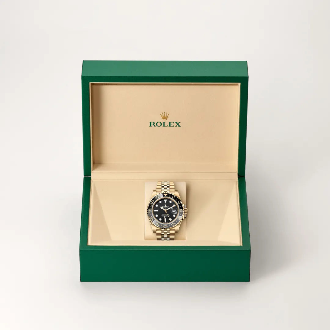Rolex GMT-Master II watch in a green and beige presentation box on a light background.