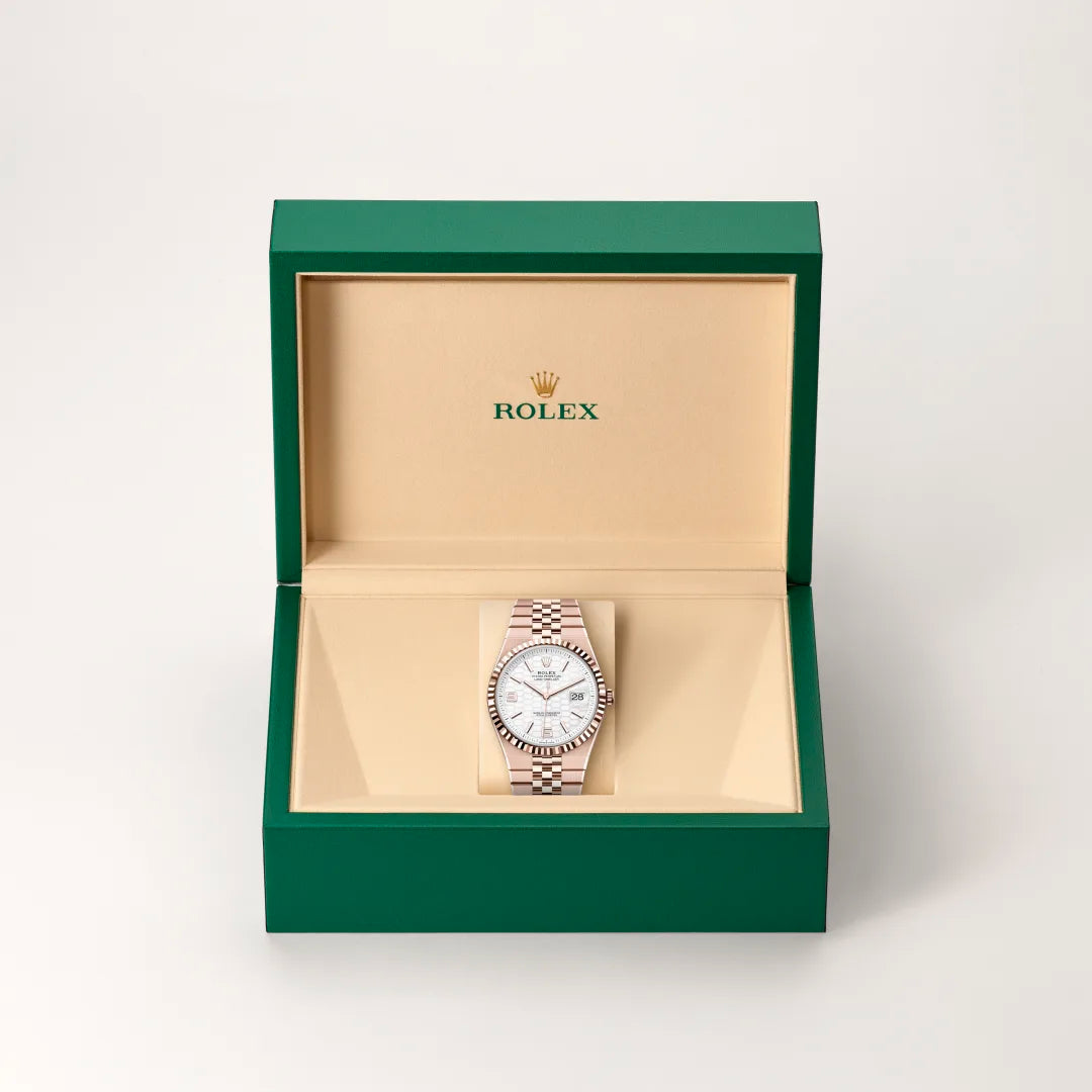 Rolex 1908 watch in a green and beige presentation box on a light background.