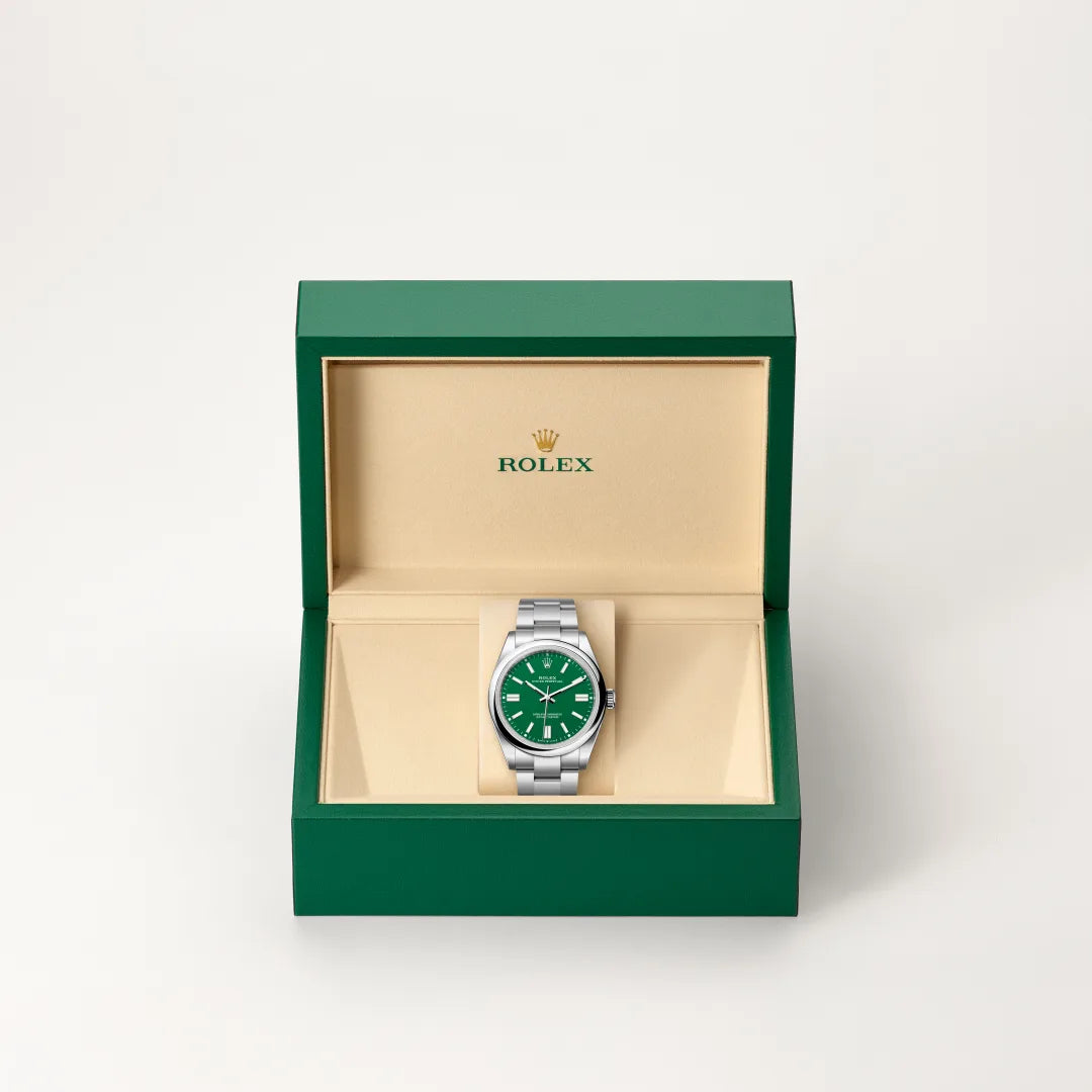 Rolex Oyster Perpetual watch in a green and beige presentation box on a light background.