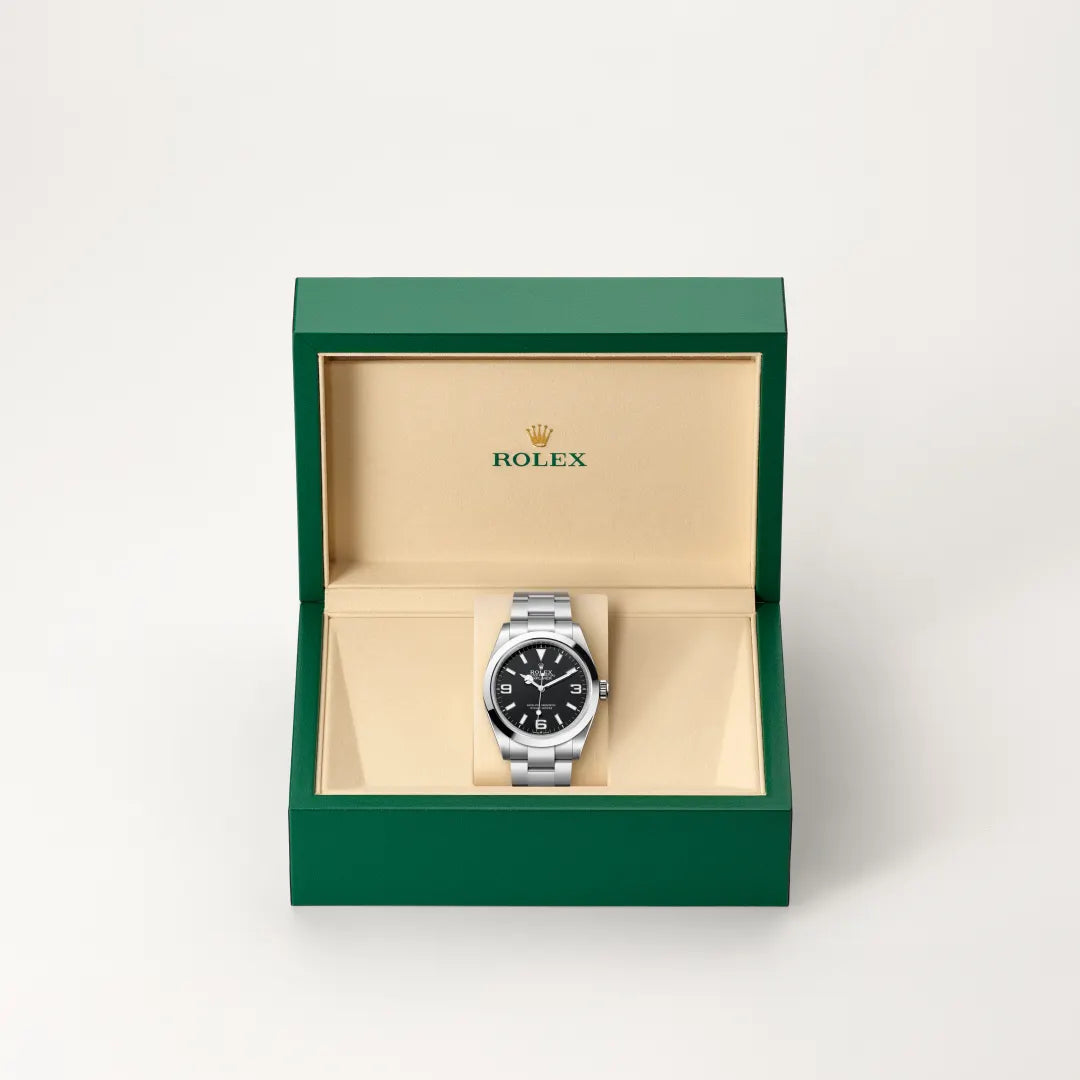 Rolex Explorer watch in a green and beige presentation box on a light background.