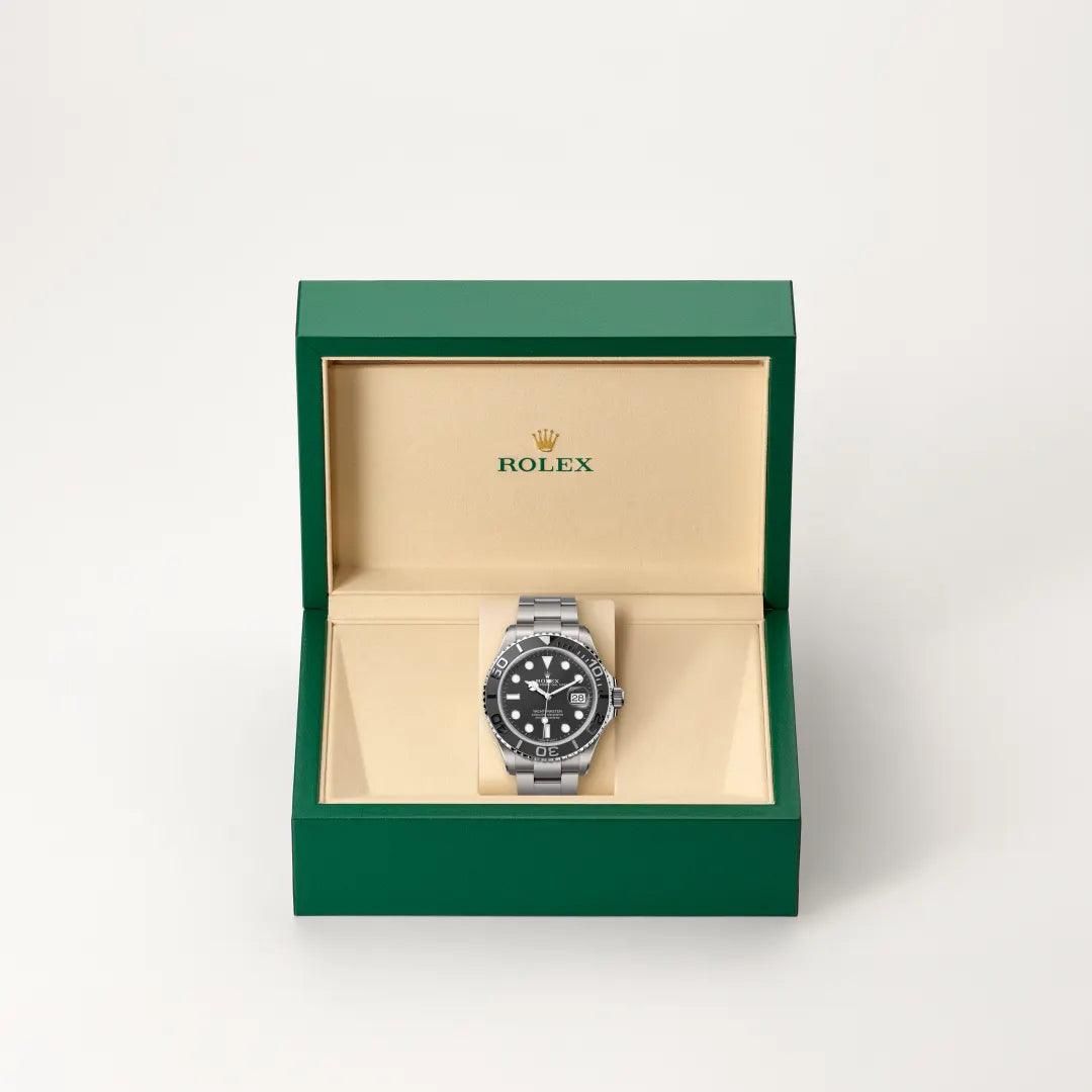 Rolex Yacht-Master watch in a green and beige presentation box on a light background.