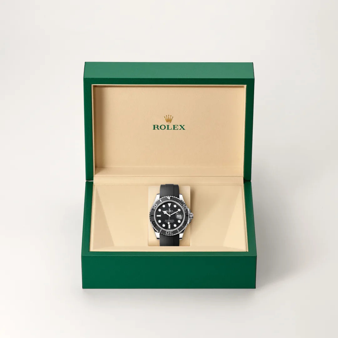 Rolex Yacht-Master watch in a green and beige presentation box on a light background.