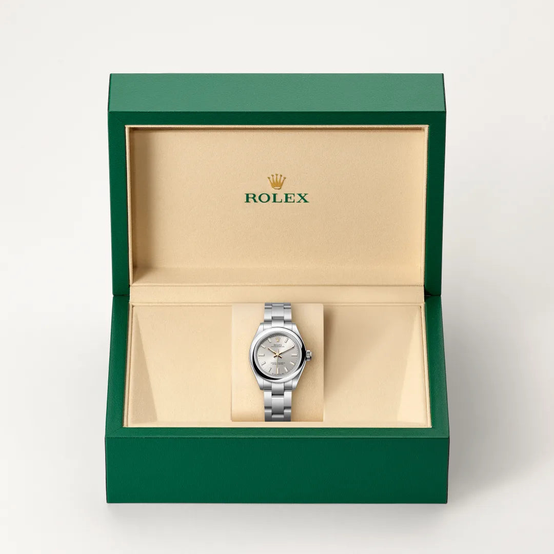 Rolex Oyster Perpetual watch in a green and beige presentation box on a light background.