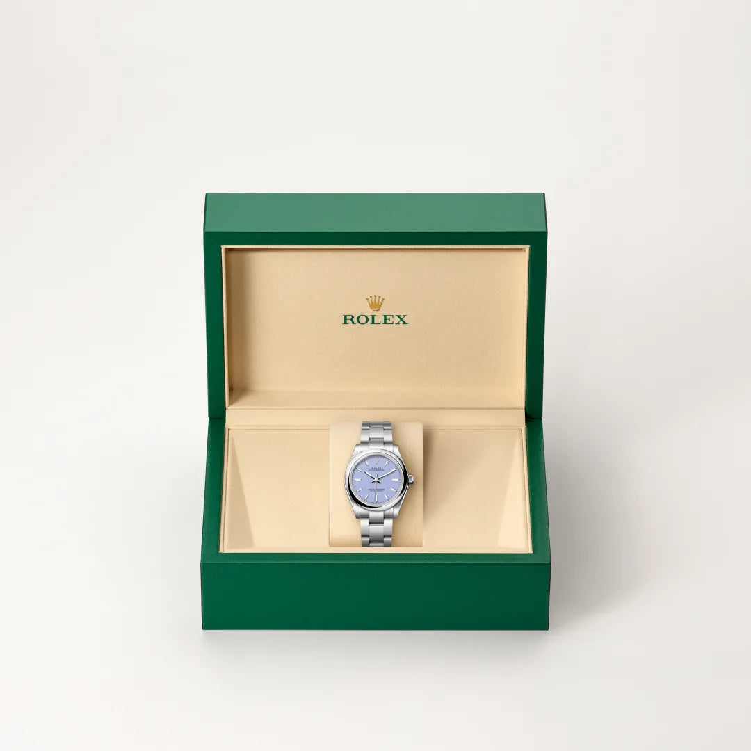 Rolex Oyster Perpetual watch in a green and beige presentation box on a light background.