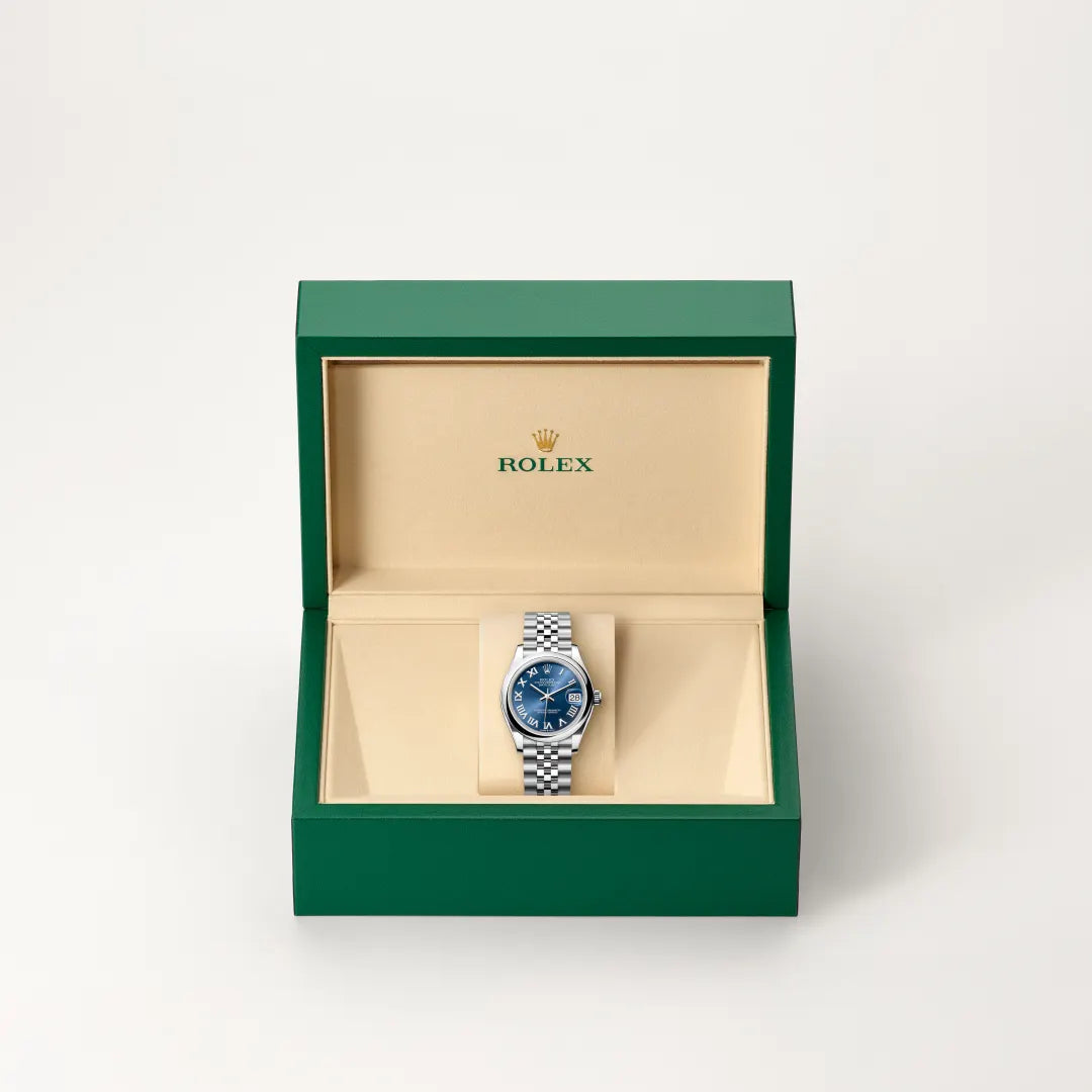 Rolex Datejust watch in a green and beige presentation box on a light background.
