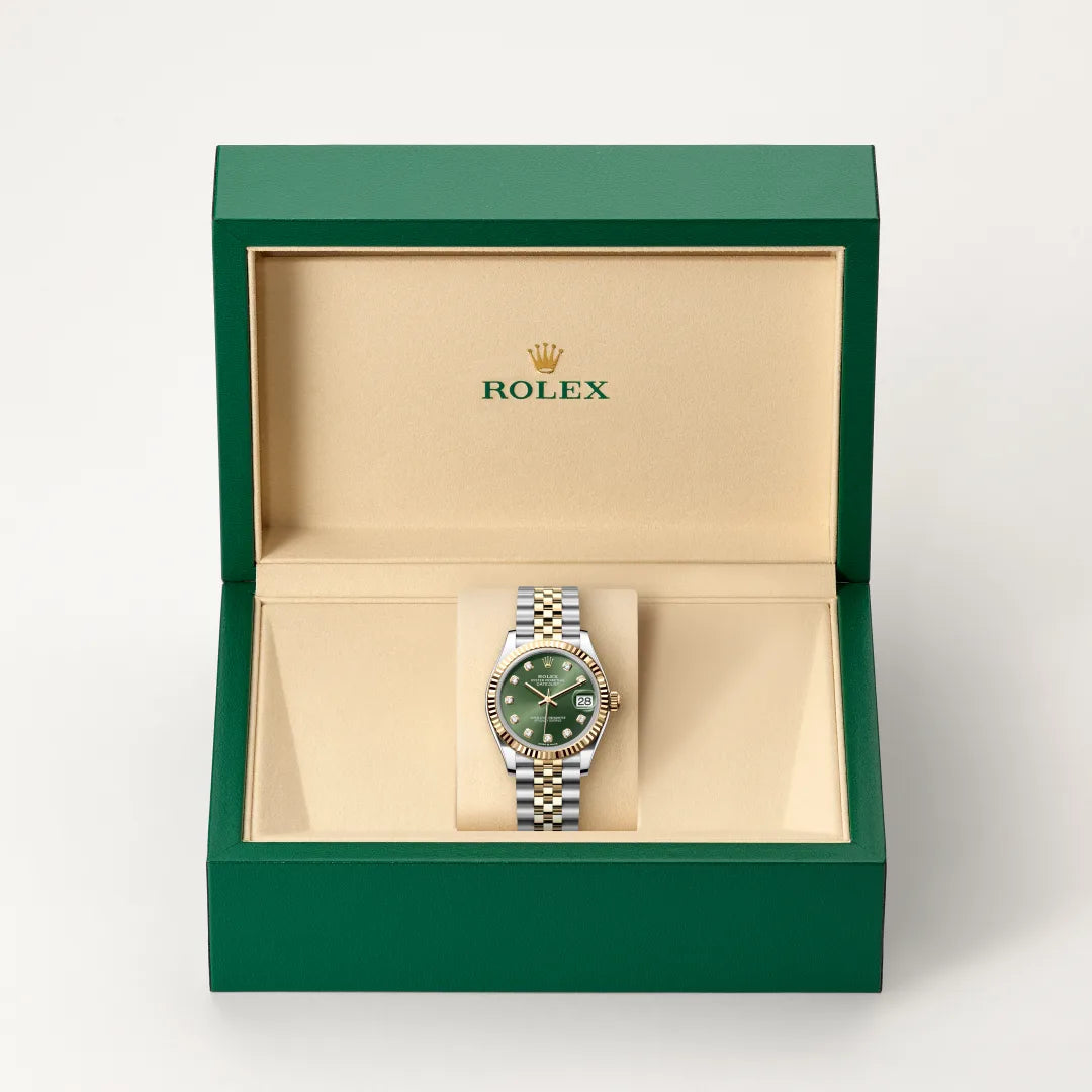 Rolex Datejust watch in a green and beige presentation box on a light background.