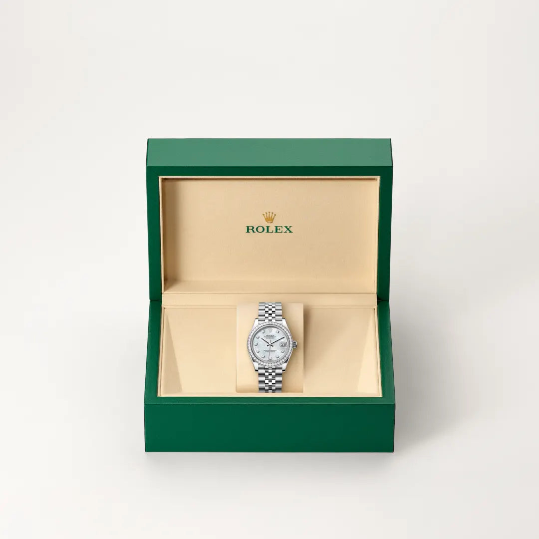 Rolex Datejust watch in a green and beige presentation box on a light background.