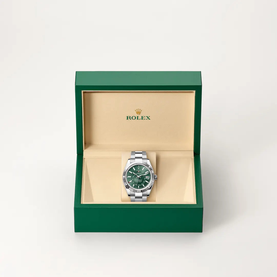 Rolex Sky-Dweller watch in a green and beige presentation box on a light background.