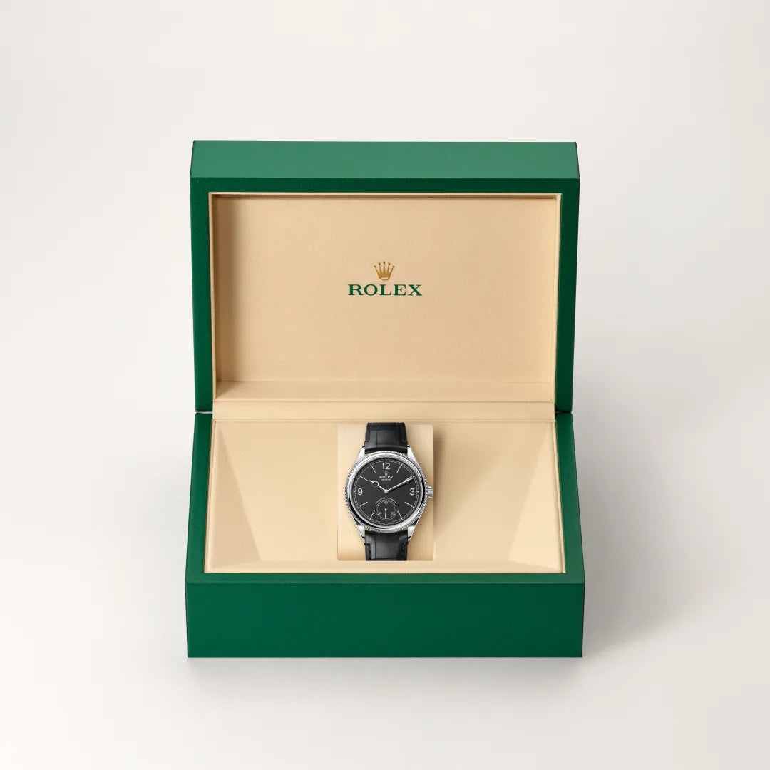 Rolex 1908 watch in a green and beige presentation box on a light background.