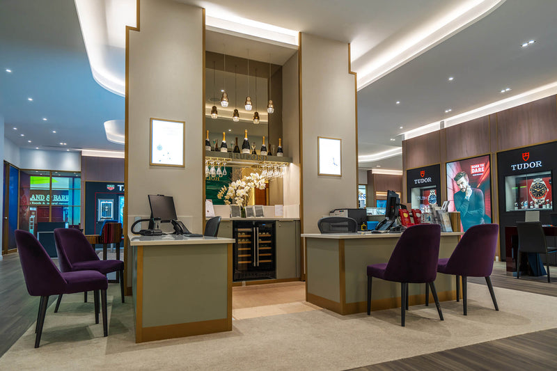 Interior of the Brufords aftersales area with purple chairs and a branded background.
