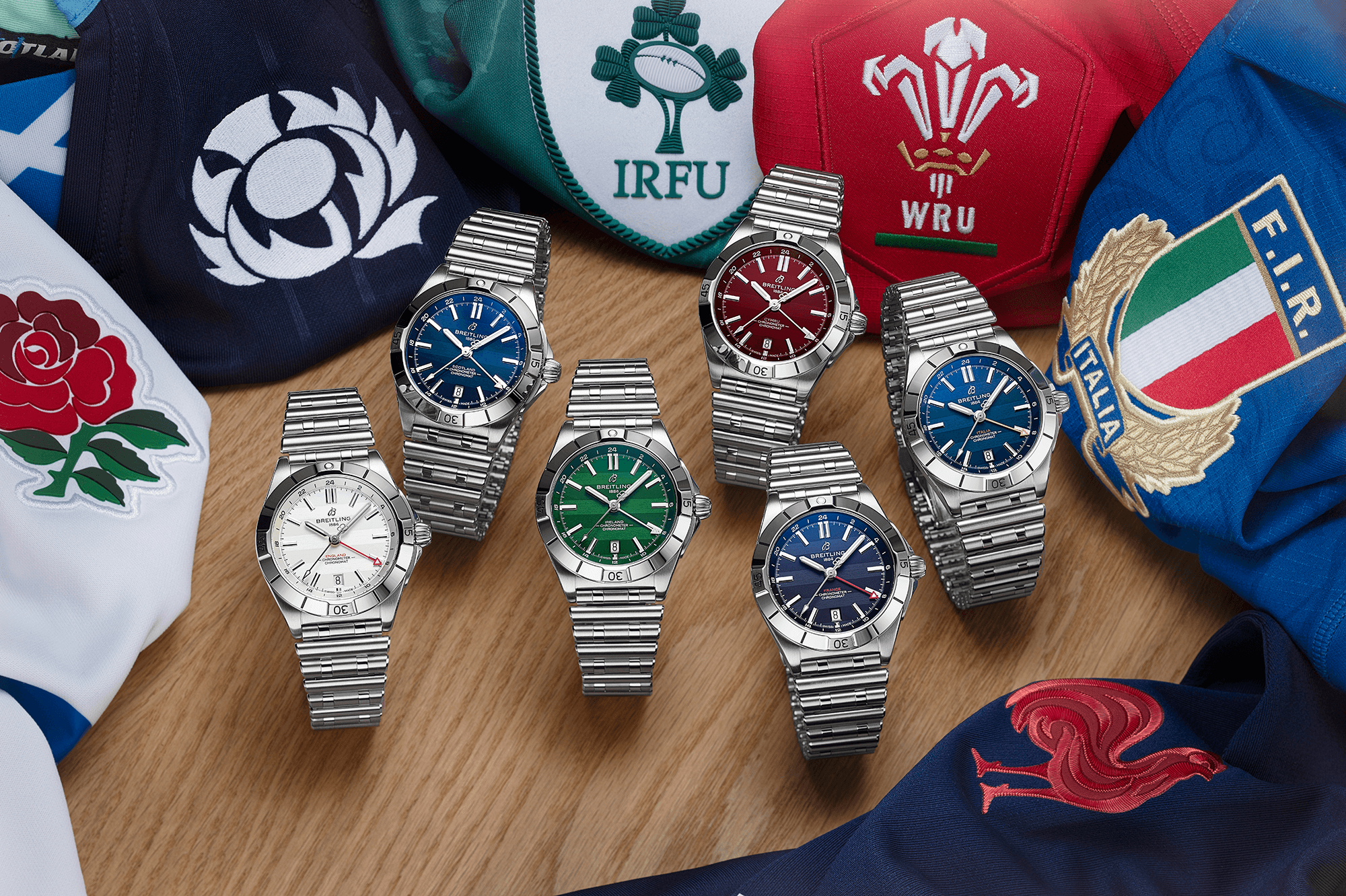 Six Breitling Chronomat Six Nations watches with various coloured dials, displayed with six national rugby team shirts.