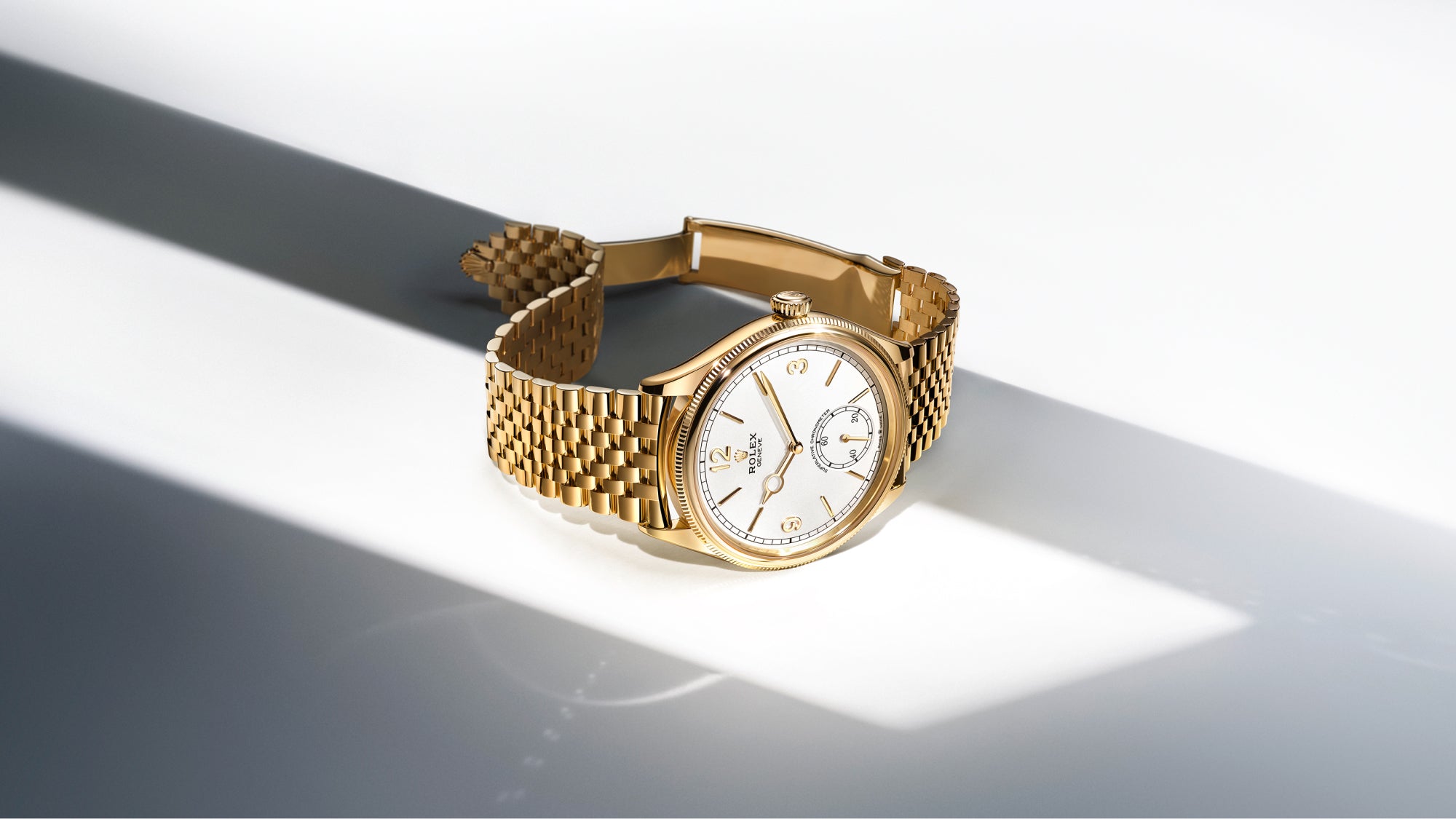 Rolex 1908 yellow-gold watch with a bracelet and white dial on a white background.