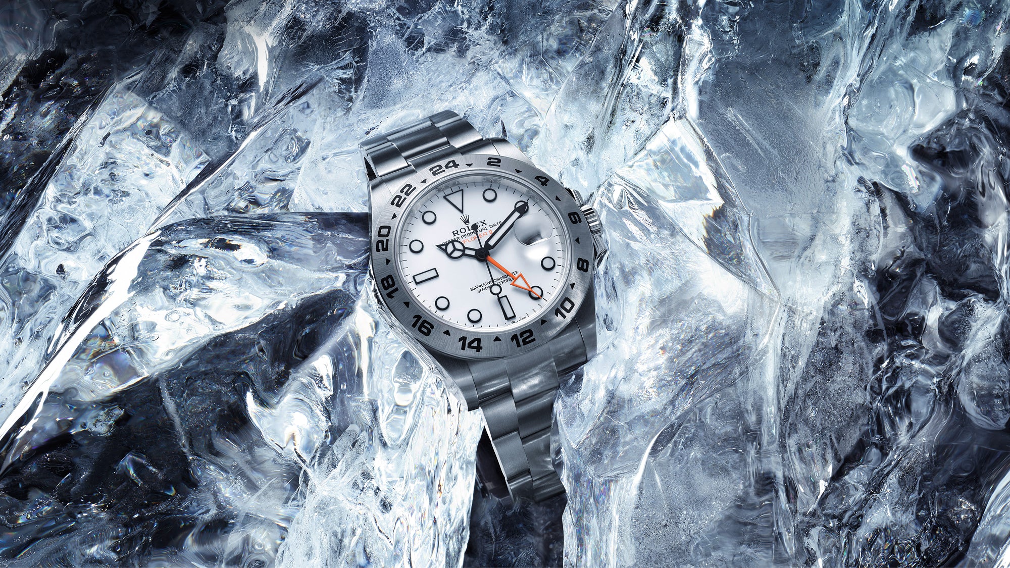 Rolex Explorer II watch with a steel bracelet and white dial on an ice background.