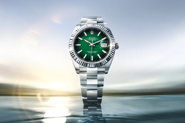 Rolex Datejust 41 watch with a steel bracelet and green dial on a sea and sky background.