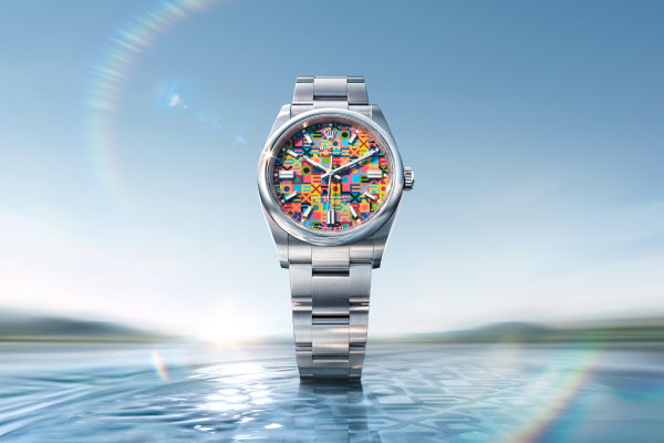 Rolex Oyster Perpetual 36 watch with a steel bracelet and multicolour dial on a sea and sky background.