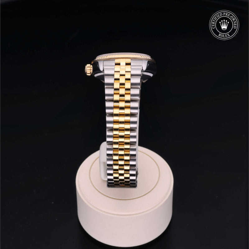 Rolex Datejust 31 with steel & yellow-gold Jubilee bracelet and champagne dial, on a cream presentation stand against a black background.Datejust 31