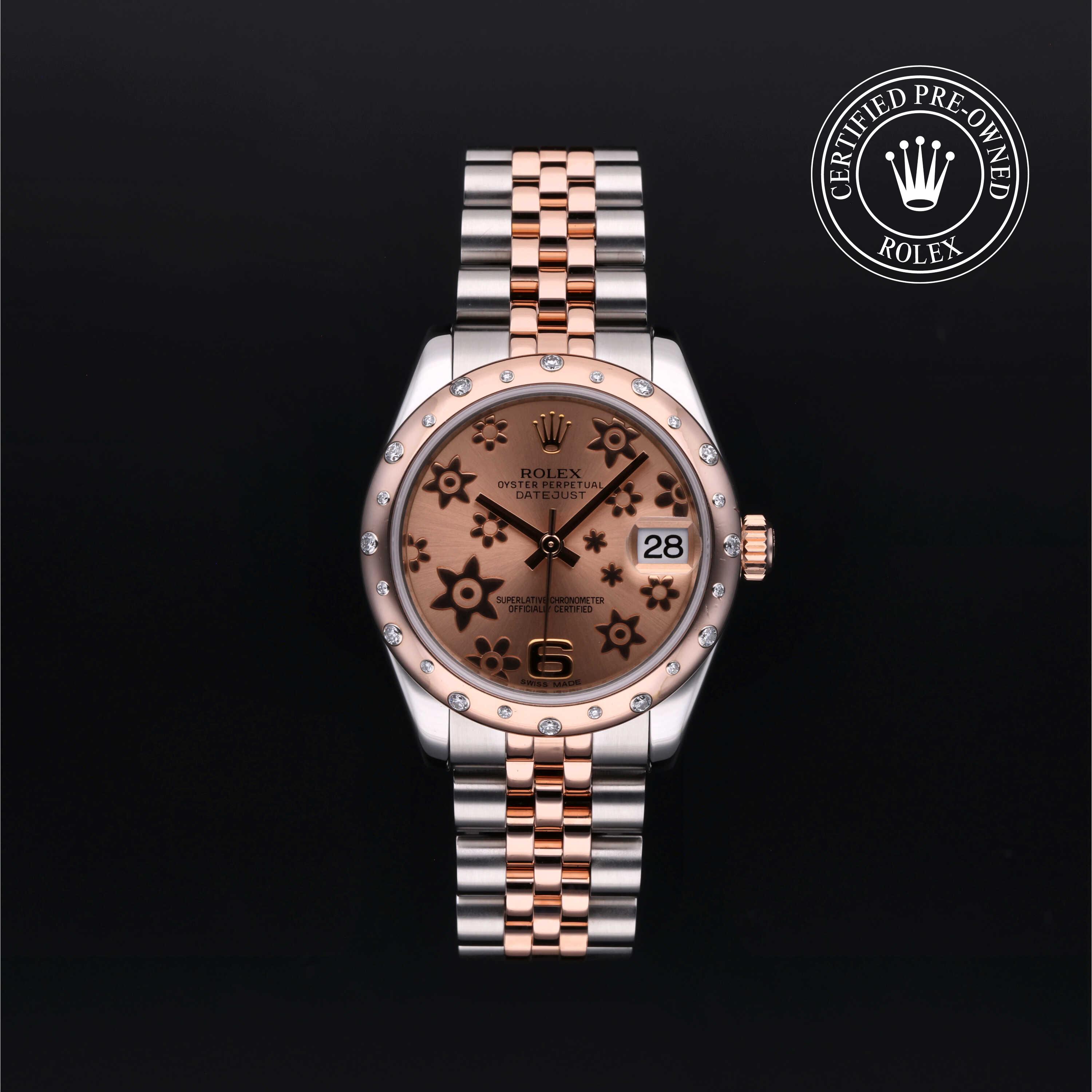 Rolex Datejust 31 in steel and Everose gold with gem-set bezel, floral motif dial and Jubilee bracelet on a black background.