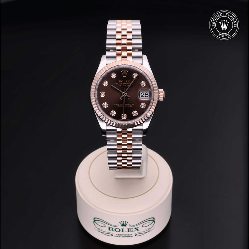 Rolex Datejust 31 with steel & Everose gold Jubilee bracelet and chocolate, diamond-set dial on a cream presentation stand against a black background.Datejust 31