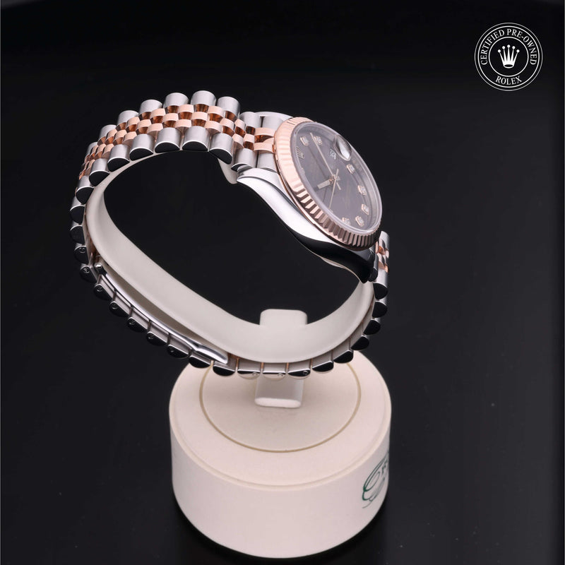 Rolex Datejust 31 with steel & Everose gold Jubilee bracelet and chocolate, diamond-set dial on a cream presentation stand against a black background.Datejust 31