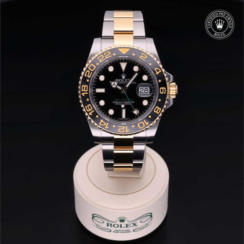 Rolex GMT-Master II watch with steel and yellow-gold Oyster bracelet and black dial on a black background.GMT-Master II