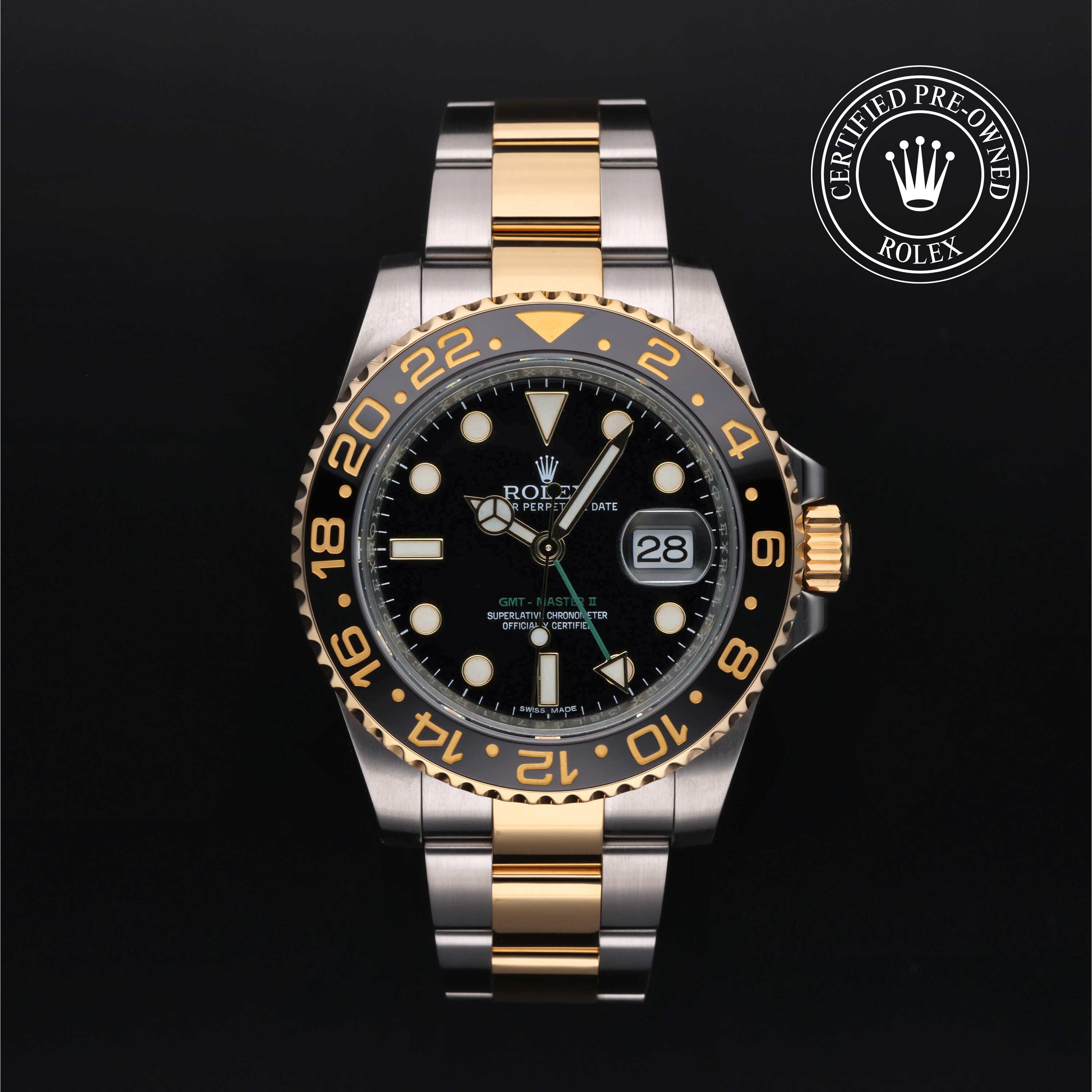 Rolex GMT-Master II watch with steel and yellow-gold Oyster bracelet and black dial on a black background.