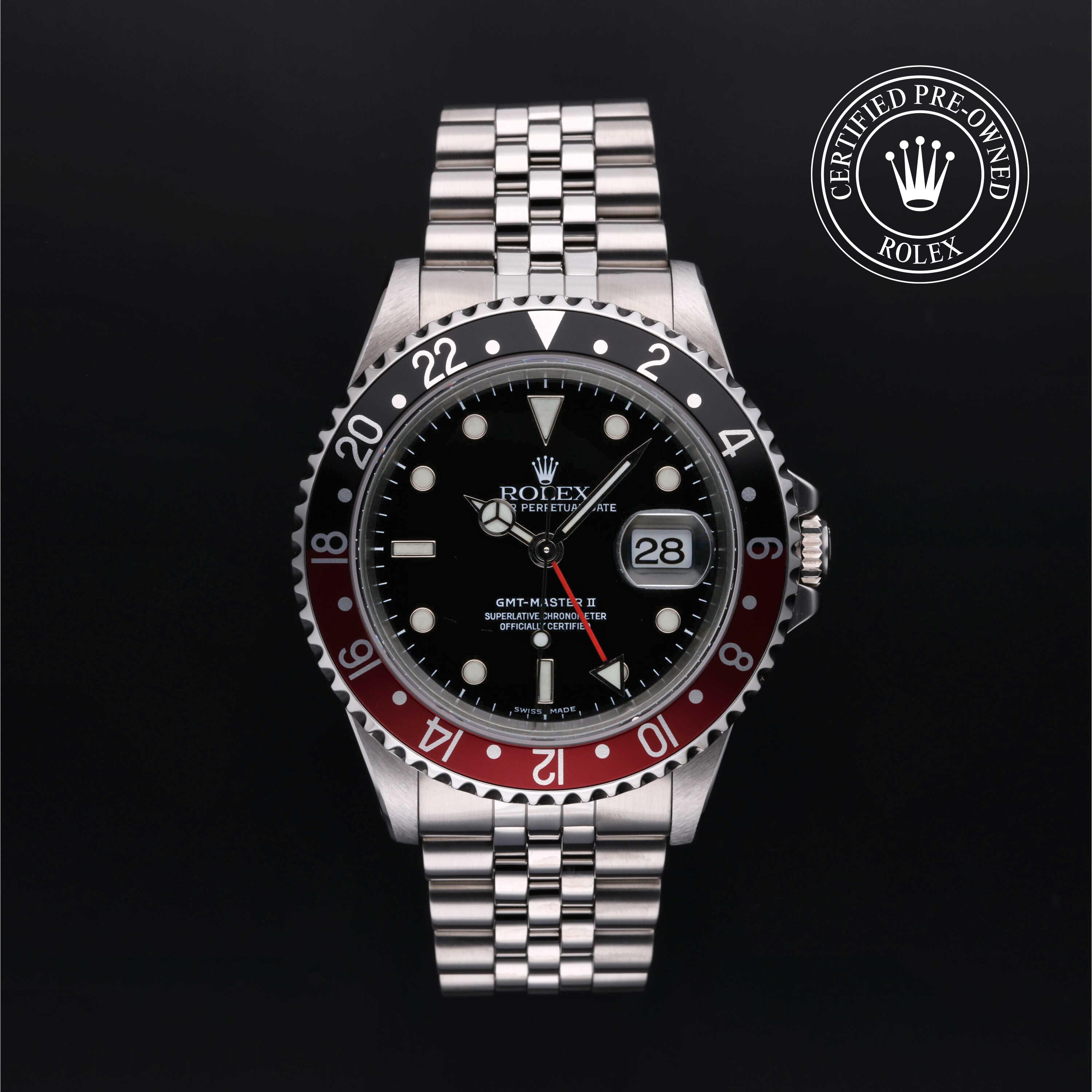 Rolex GMT-Master II with Jubilee bracelet, red and black bezel and black dial on a black background.